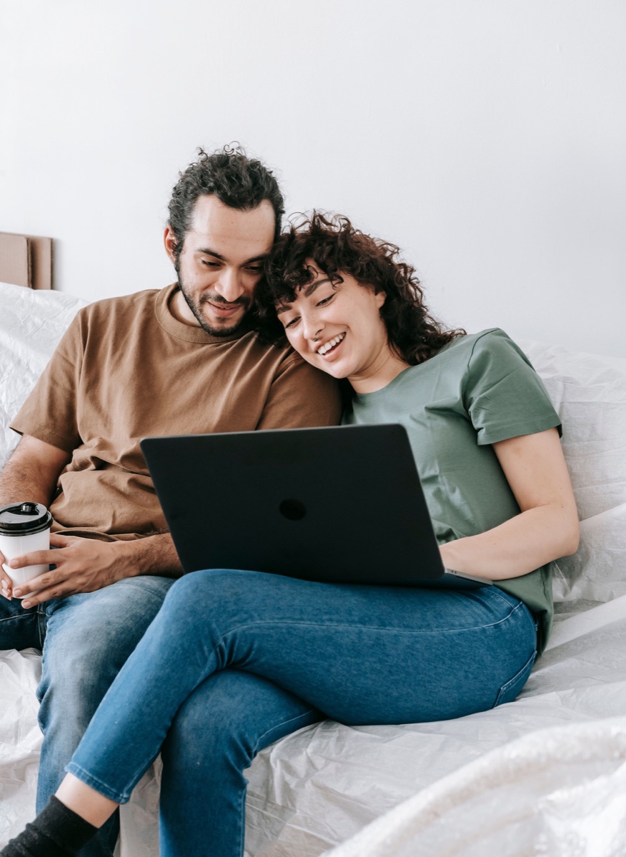 Paar plant gemeinsam auf dem Sofa mit einem Tablet