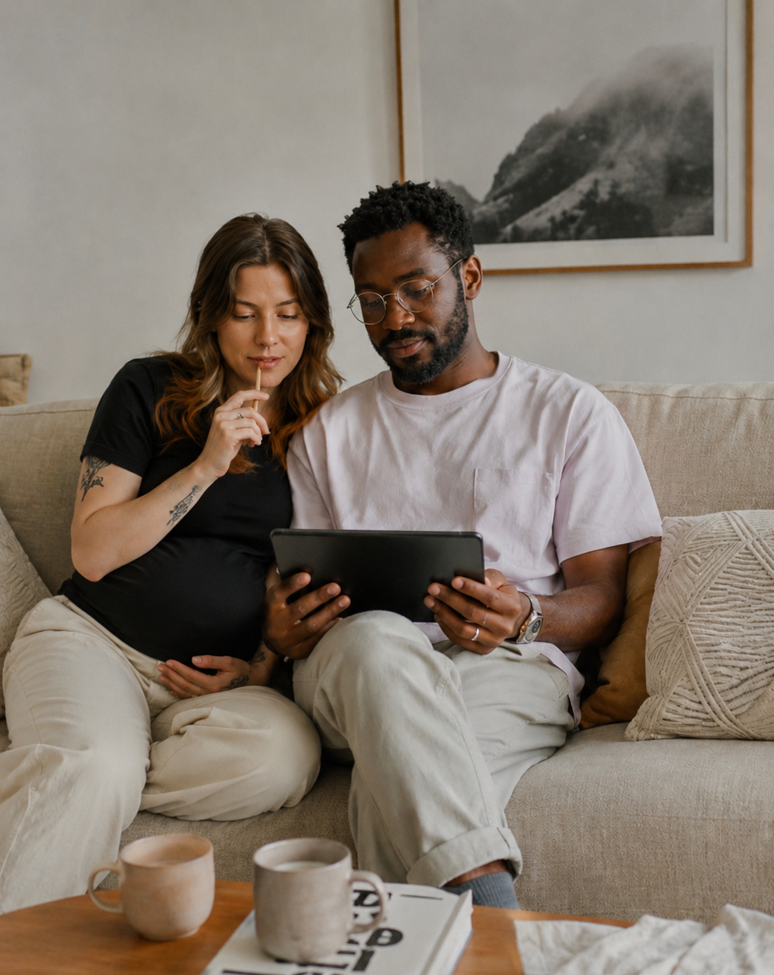 Paar plant gemeinsam auf dem Sofa mit einem Tablet